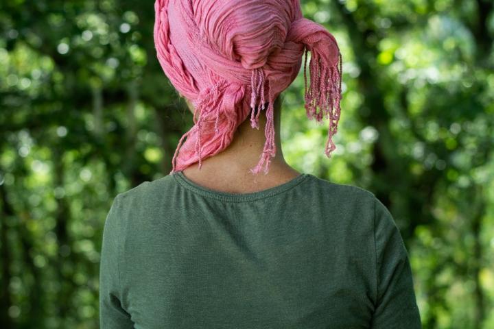 Person wearing green with pink head scarf